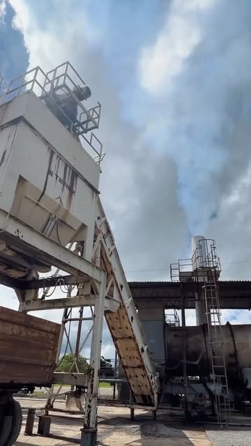 Torre y banda transportadora de la planta de asfalto junto a un camión