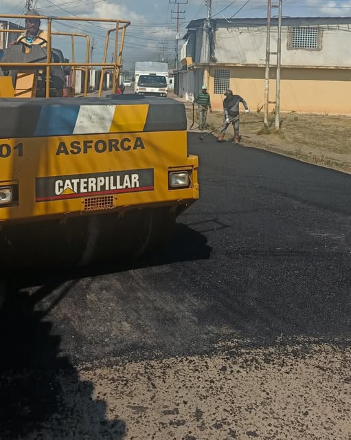 Compactadora amarilla con el nombre ASFORCA trabajando sobre asfalto recién tendido