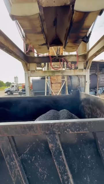 Batea de un camión con material recién cargado bajo la tolva de la planta de ASFORCA